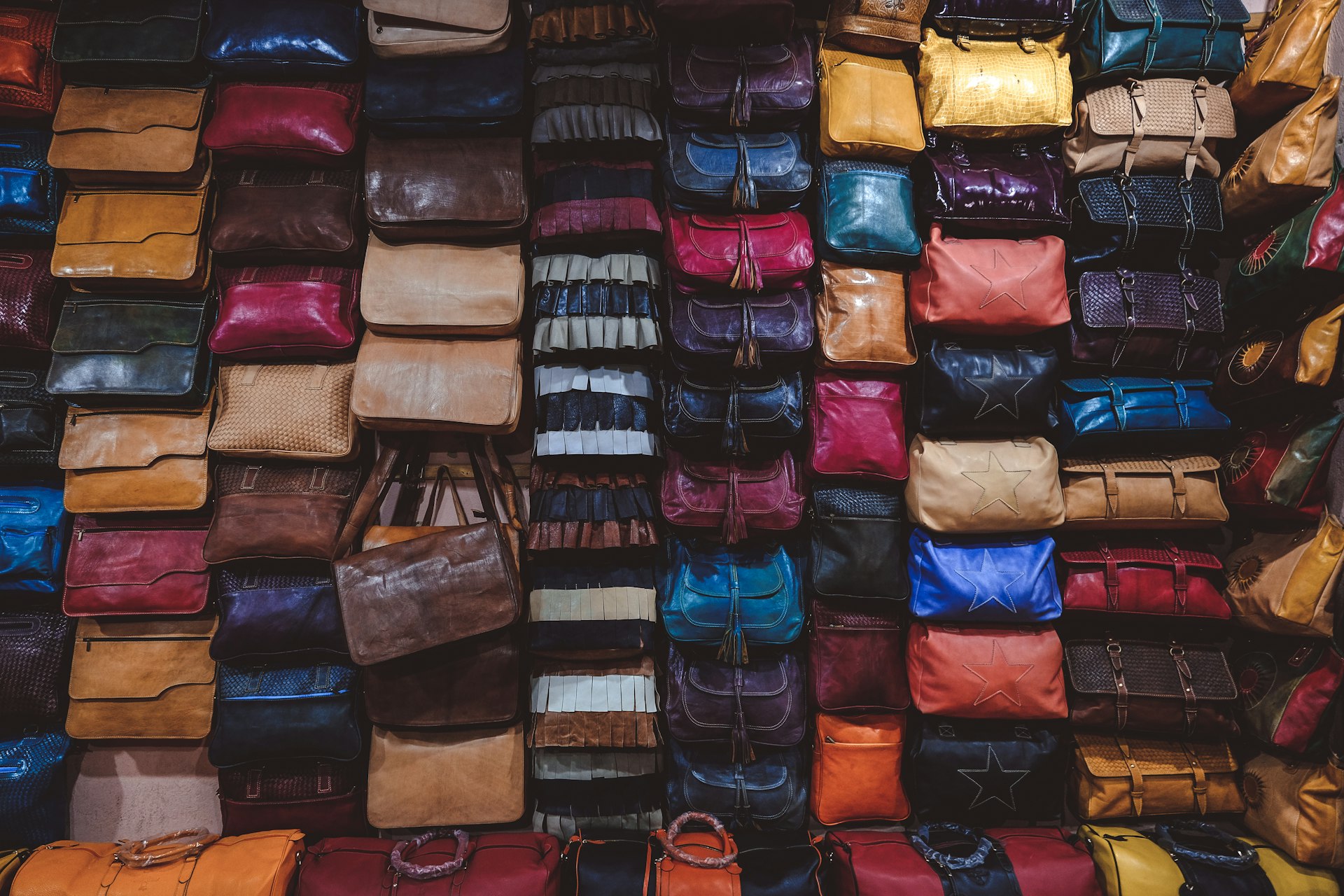 a large pile of different colored bags on display